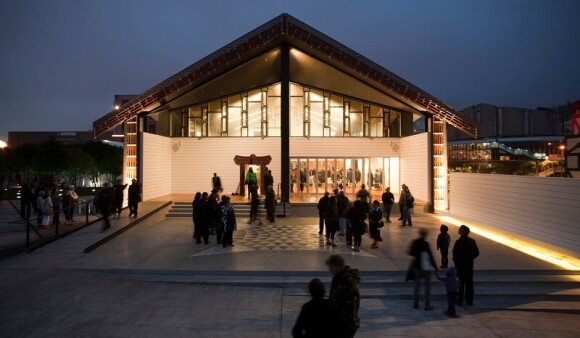The Wharewaka on the Wellington waterfront, at night and warmly lit from within