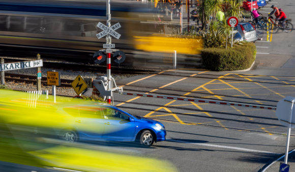 A sunny Wellington city street with cars, trains and bike passing in a motion blur