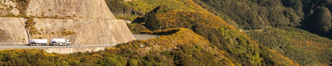 A truck drives along a hillside road